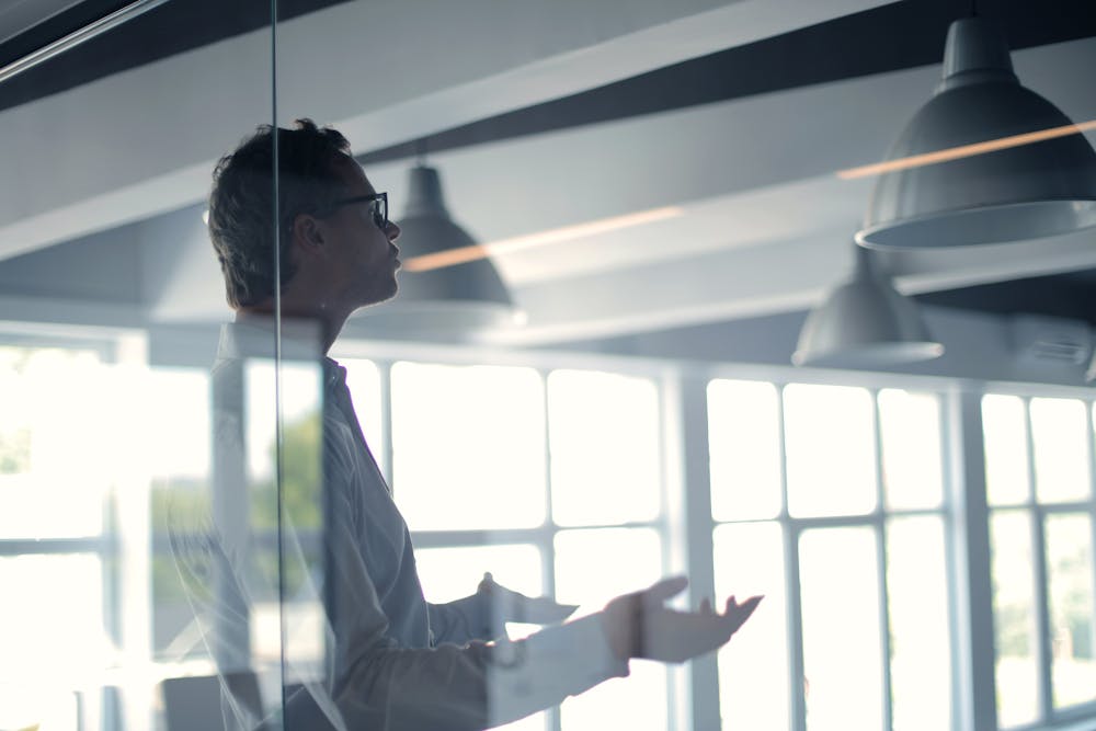 Male employer gesticulating and explaining idea in light office Male employer gesticulating and explaining idea in light office